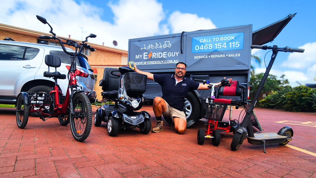 Man posing with a variety of e-scooters, mobility scooters, and e-bikes in front of a branded service vehicle, highlighting mobile repair services by My Eride Guy.