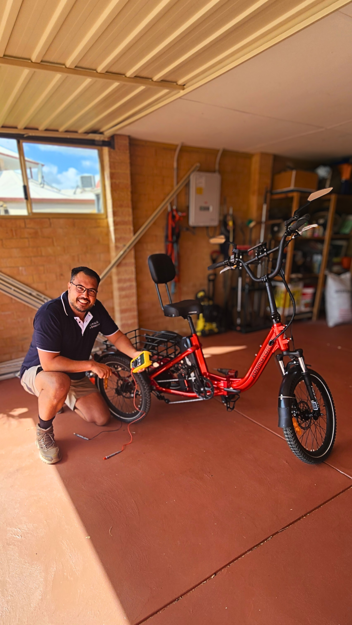Technician performing maintenance on a red e-bike in a garage, showcasing mobile e-scooter repair services by My Eride Guy.
